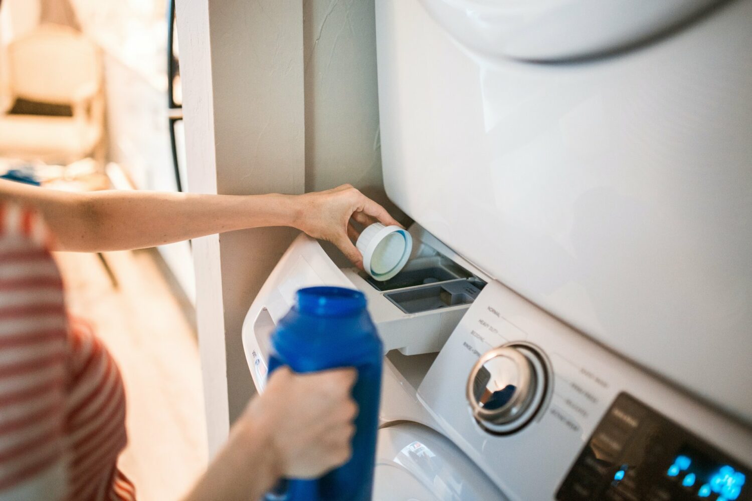 Woman using the washing machine - how to lighten jeans