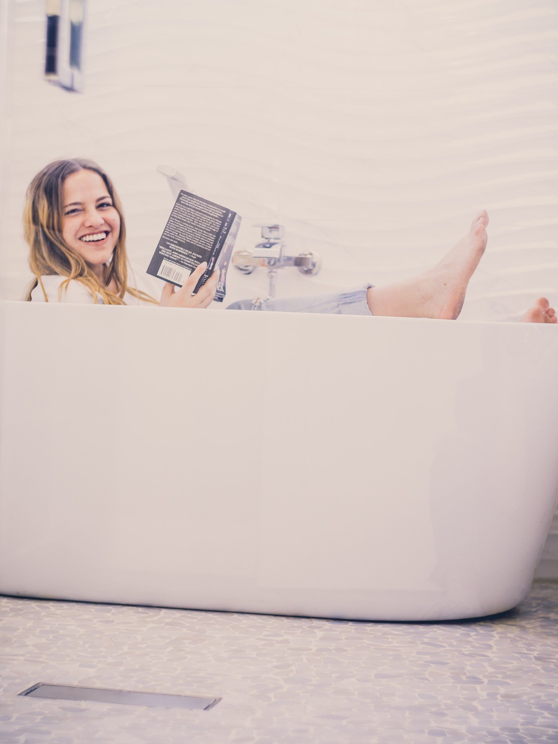 Woman testing how to shrink stretch jeans in the bath tub