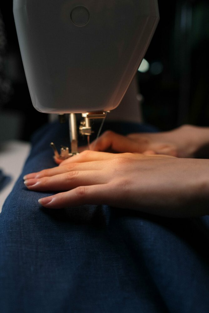 Woman altering jeans with sewing machine