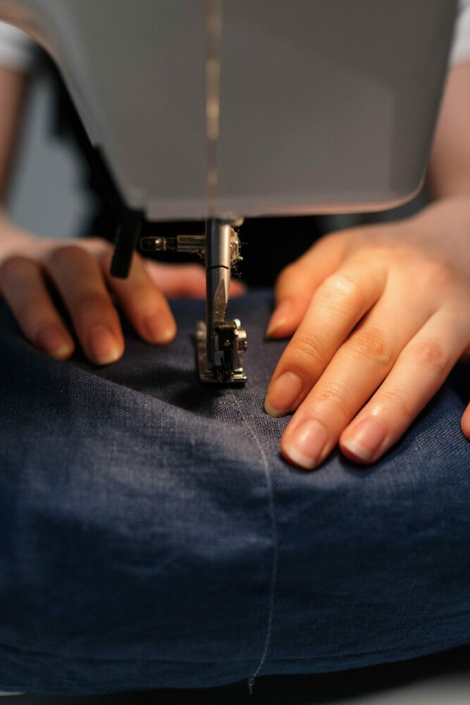 Woman altering jeans with sewing machine