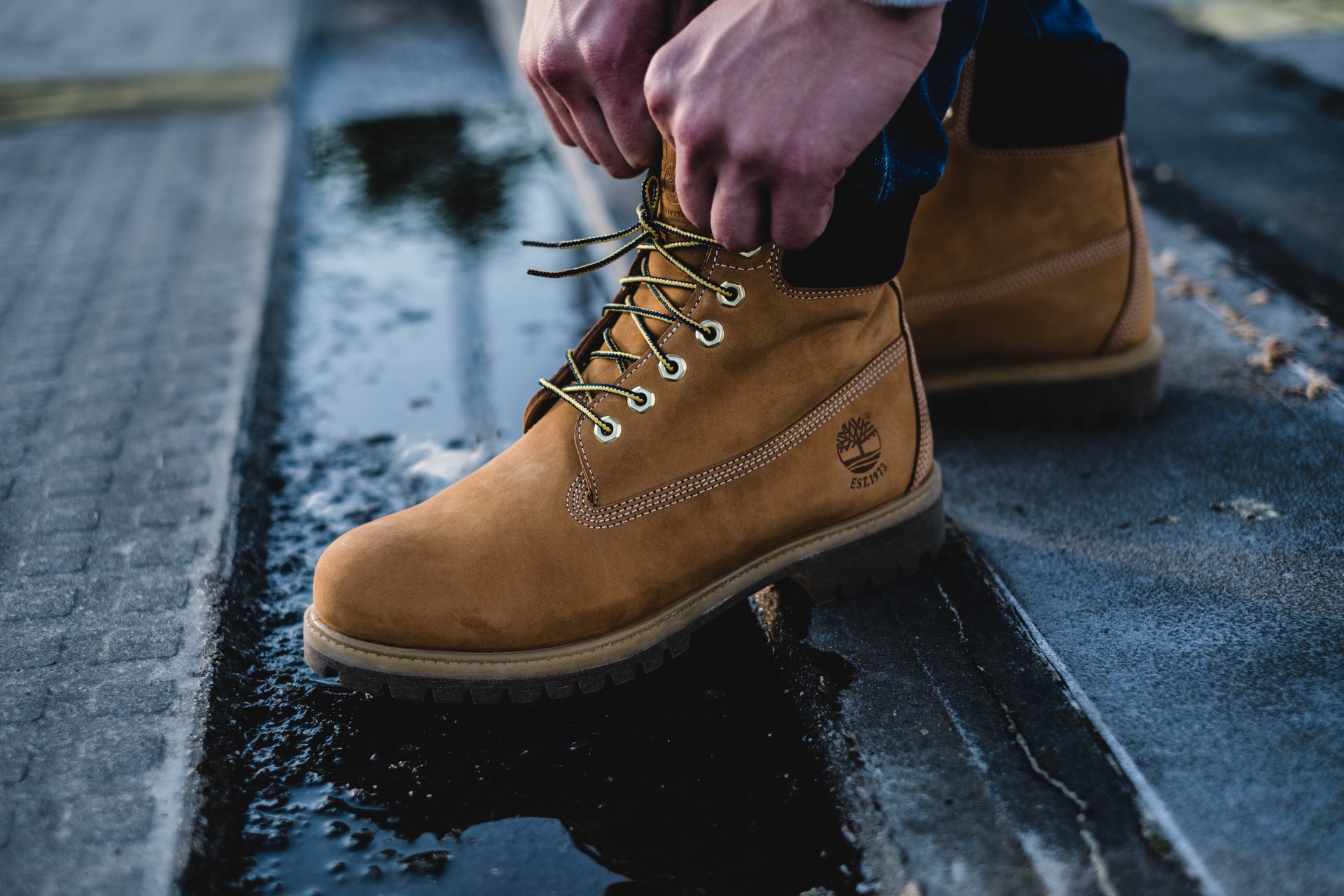 How to wear Timbs with jeans - Man fixing Timbs boots